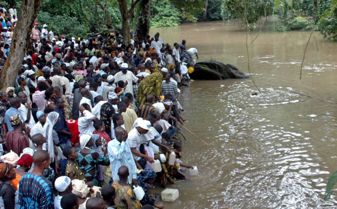 People gather at the Osun sacred river to collect water during the annual worship festival of a river goddess in Osogbo